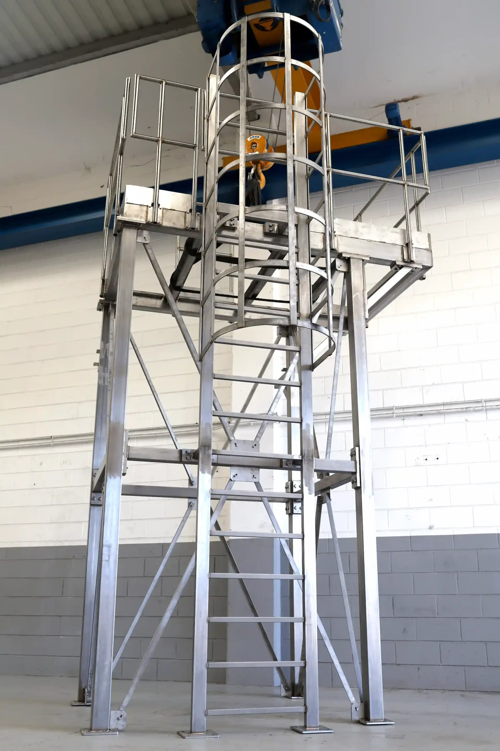 Estructura metálica industrial con plataforma, escalera y barandillas fabricada a medida.